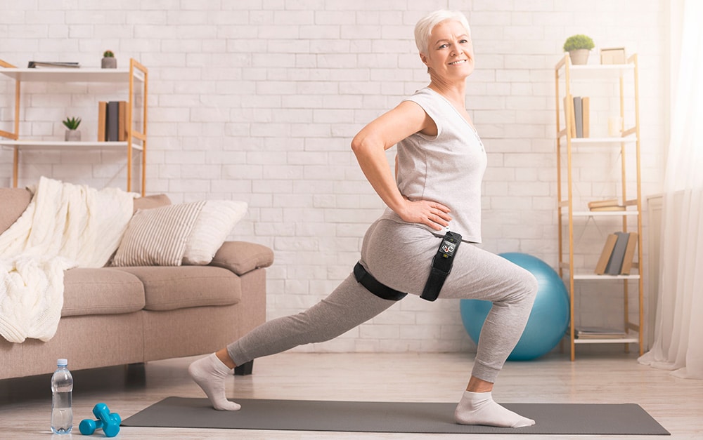 Middle aged woman doing lunges while wearing KAATSU Air Bands on her legs